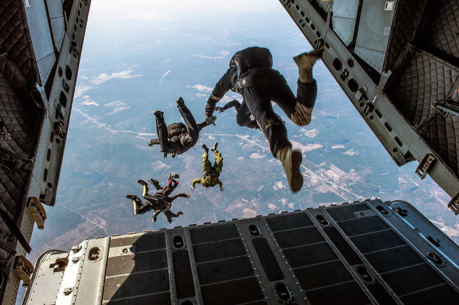 Paratroopers exiting a military transport aircraft